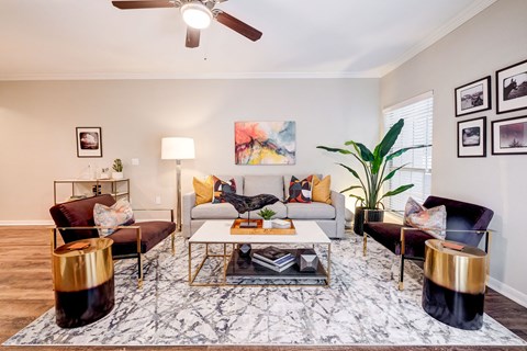 a living room with furniture and a ceiling fan